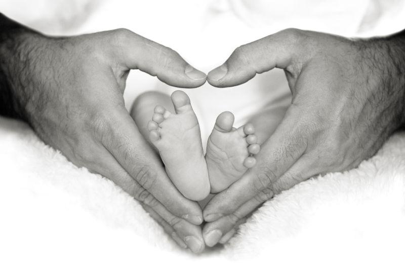 父亲双手比成心形里的婴儿小脚