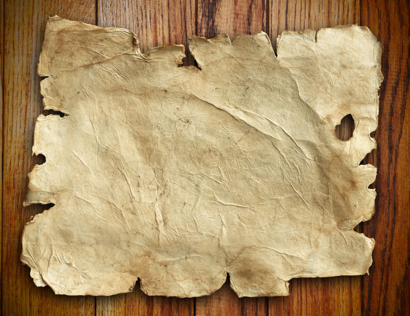旧木桌上的旧羊皮纸