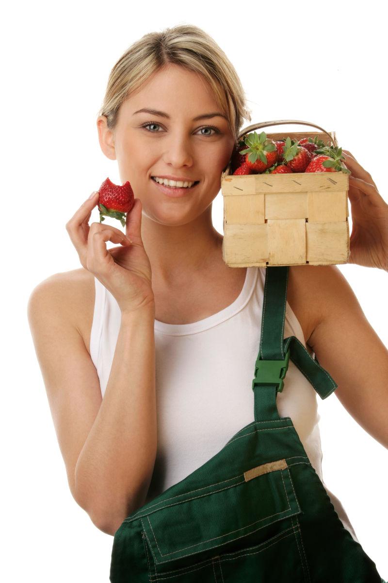 美女肩膀上装着草莓的木篮子