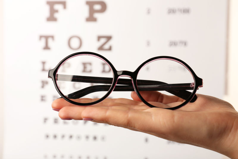 女性手上戴眼镜的视力测试图
