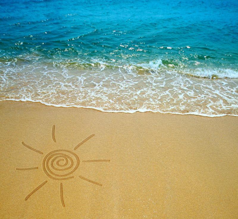在海滩上画微笑的太阳符号和美丽的大海
