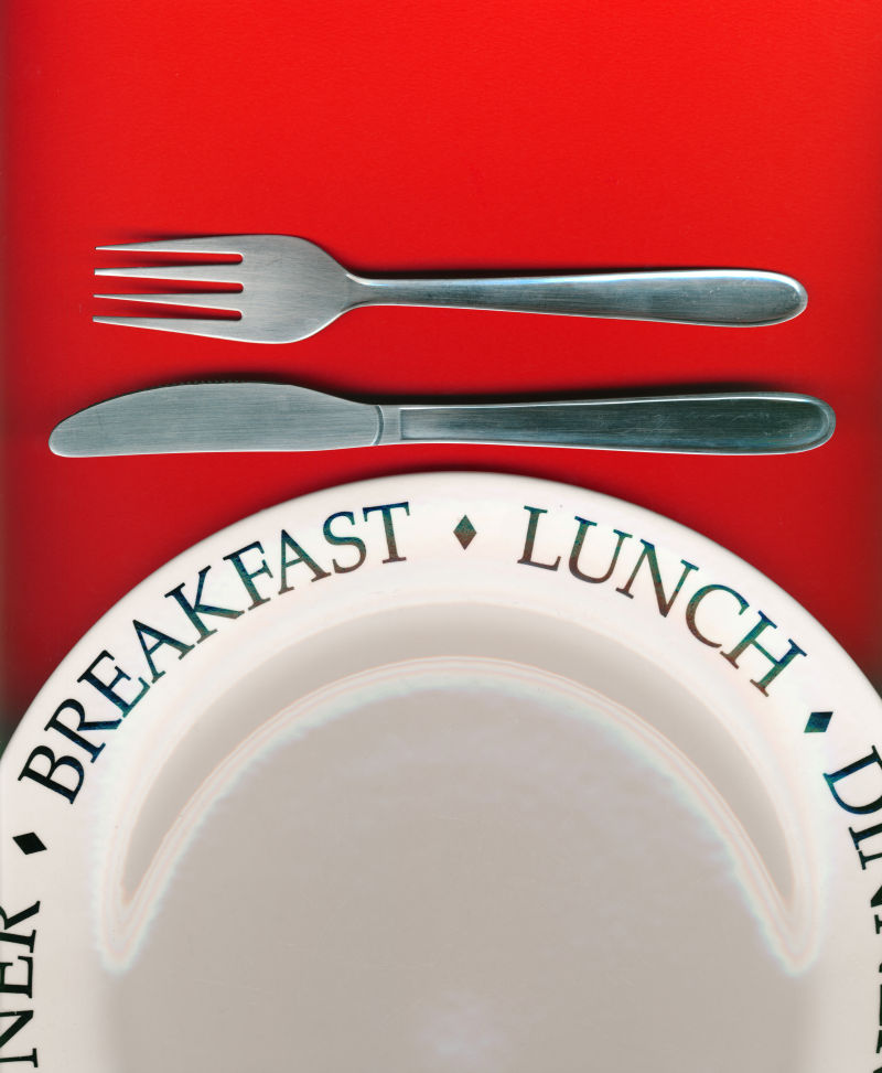 红色背景上的白色餐盘和刀叉等餐具