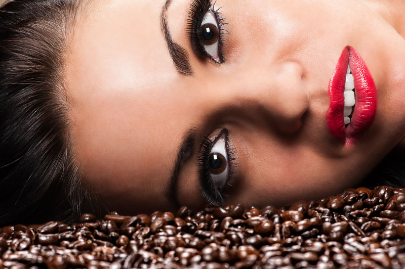 美女将脸趴在咖啡豆上