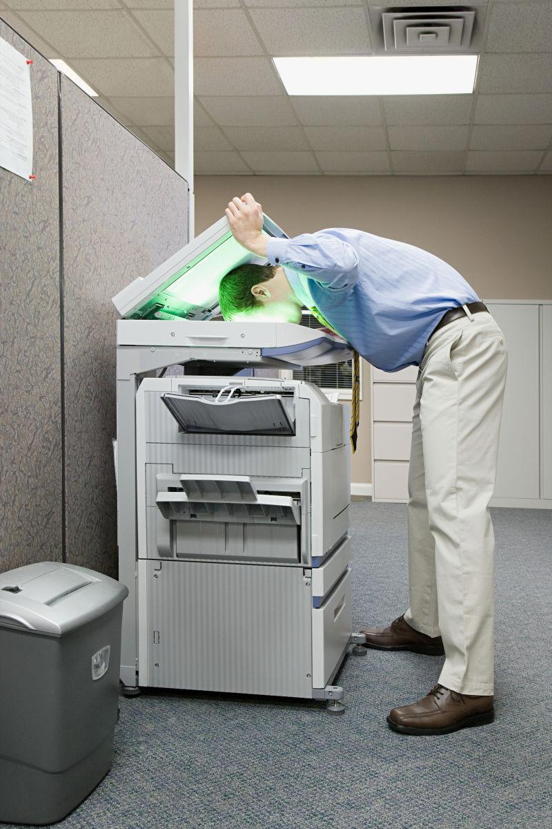 办公室里把脸贴在印刷机上的男人