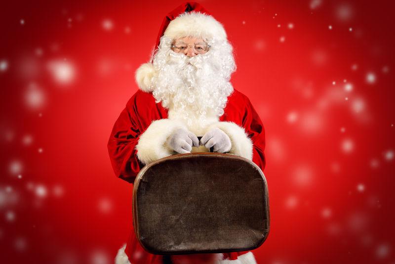 红色背景下拿包的圣诞老人