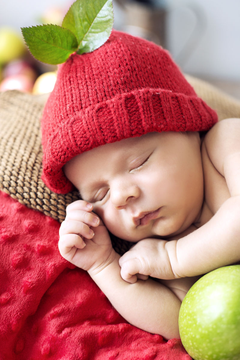 戴着红色帽子入睡的婴儿