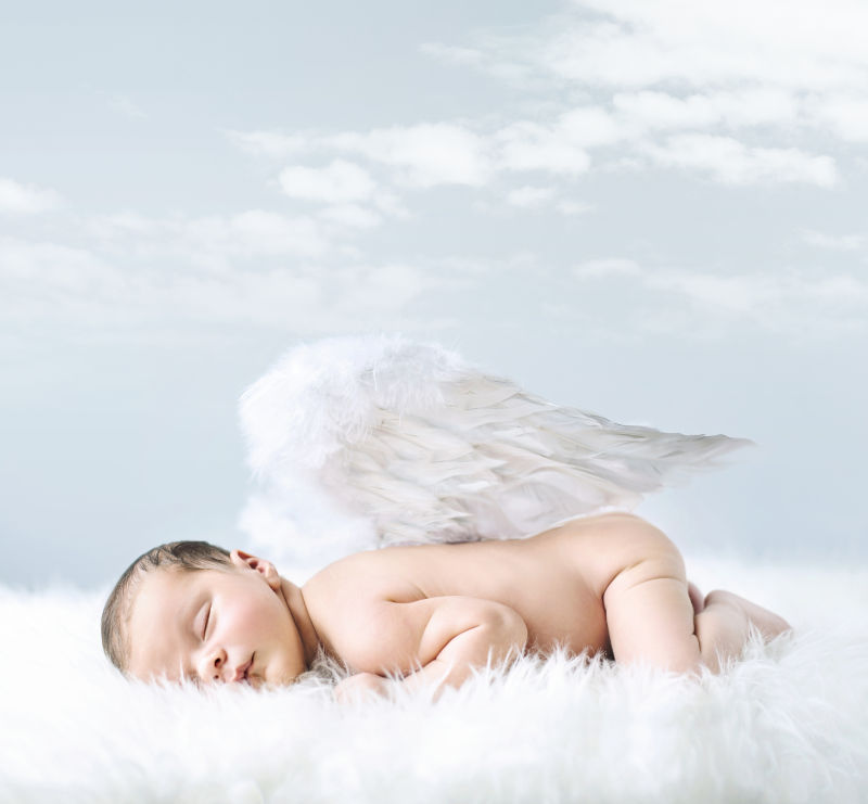 戴着白色翅膀睡觉的宝宝