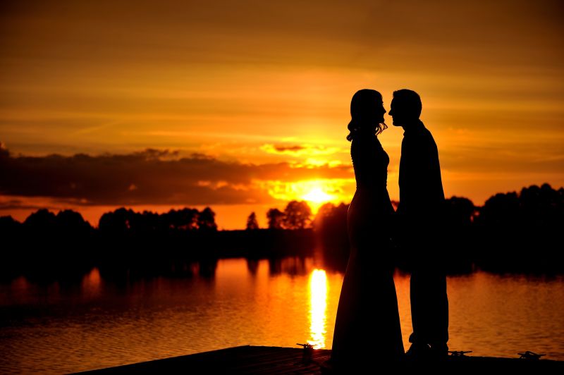 夕阳下情侣在湖边亲吻剪影