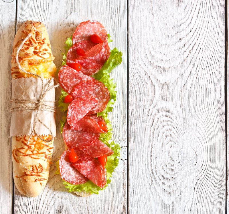 白色木板上的意大利香肠三明治