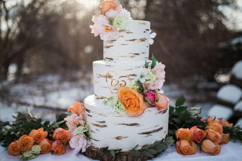 阳光下的森林背景下玫瑰花装饰的结婚蛋糕