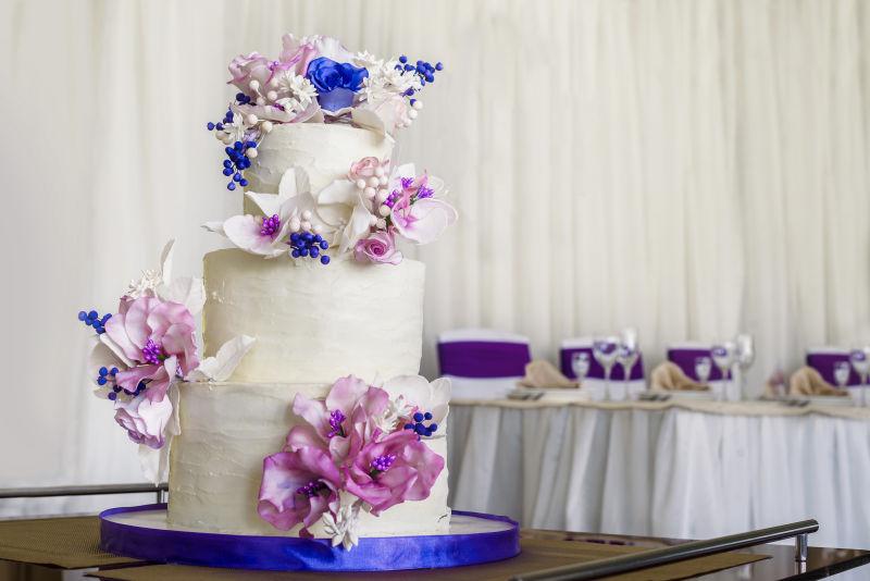 蓝色和白色花朵装饰的白色结婚蛋糕