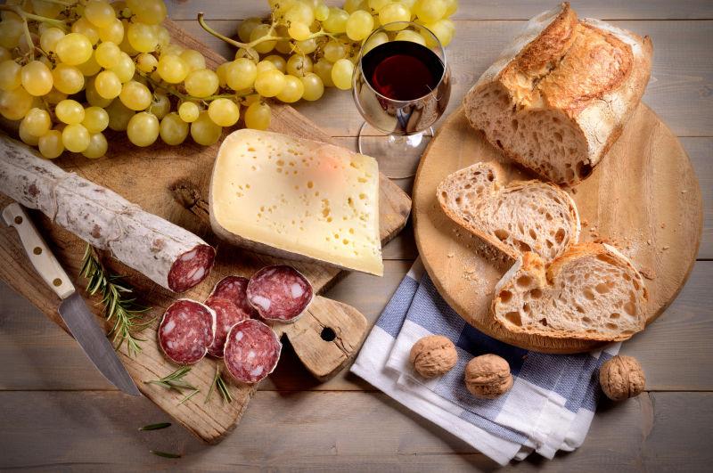 木桌上的香肠和奶酪以及葡萄