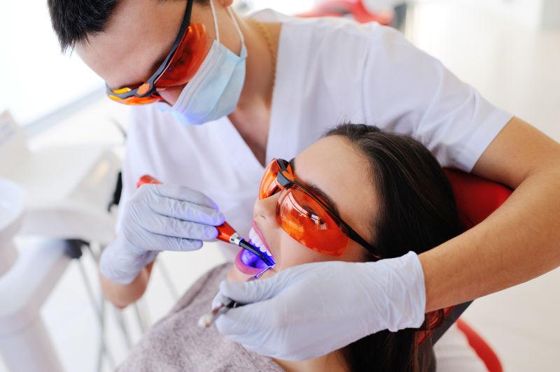 一名男性牙医正在给一个病人填充牙齿