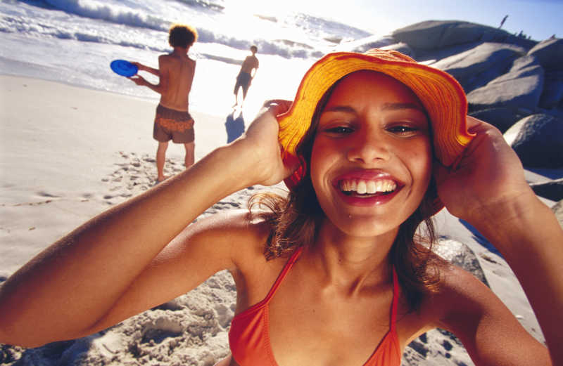 假日海滩上脸上洋溢着幸福微笑的西方年轻美女