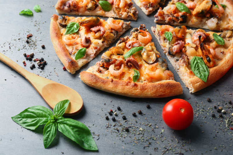 美味的比萨和海鲜西红柿放在灰色的背景下