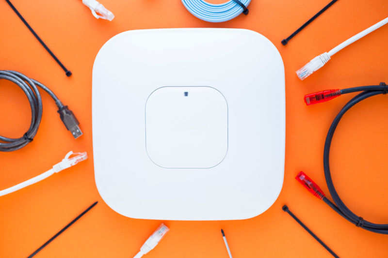 公司网络概念一套以太网交换机接入点电缆连接器橙色背景的笔记本电脑俯视图文本空间闭合