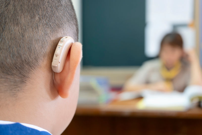 佩戴助听器以提高听力效率的学生