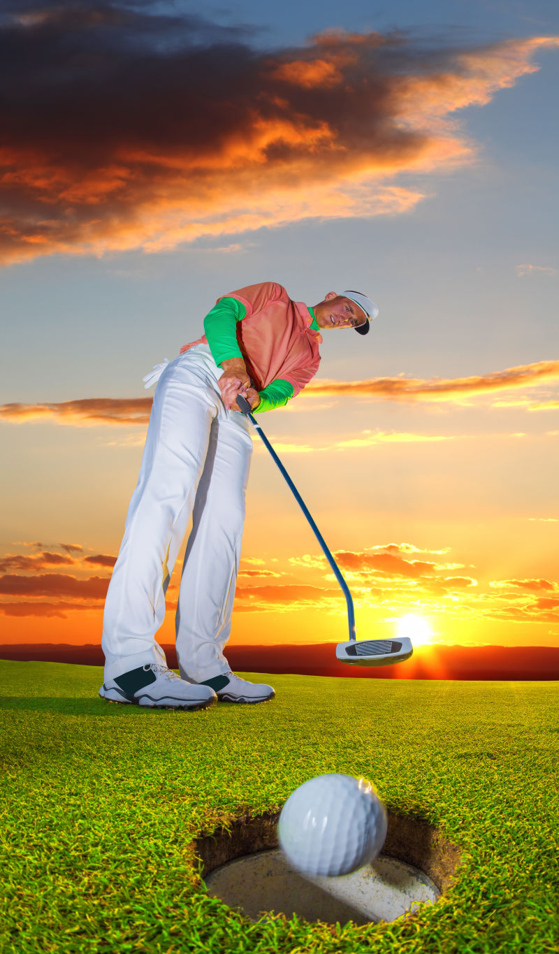 在绚丽的日落下打高尔夫球的男人