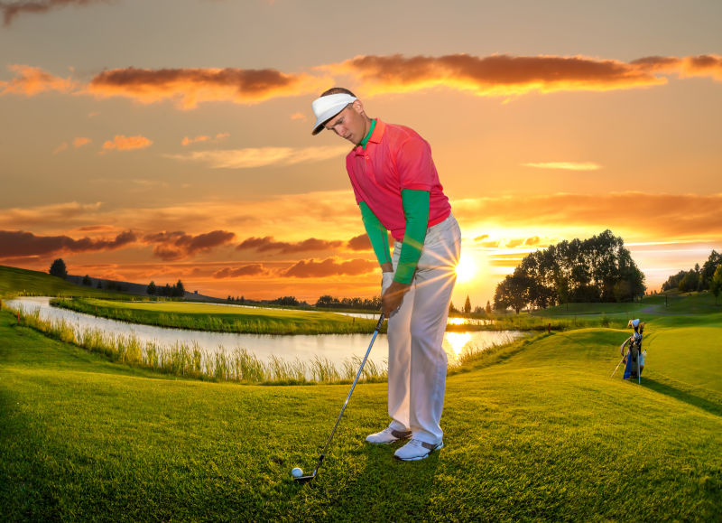 在绚丽的日落下打高尔夫球的男人