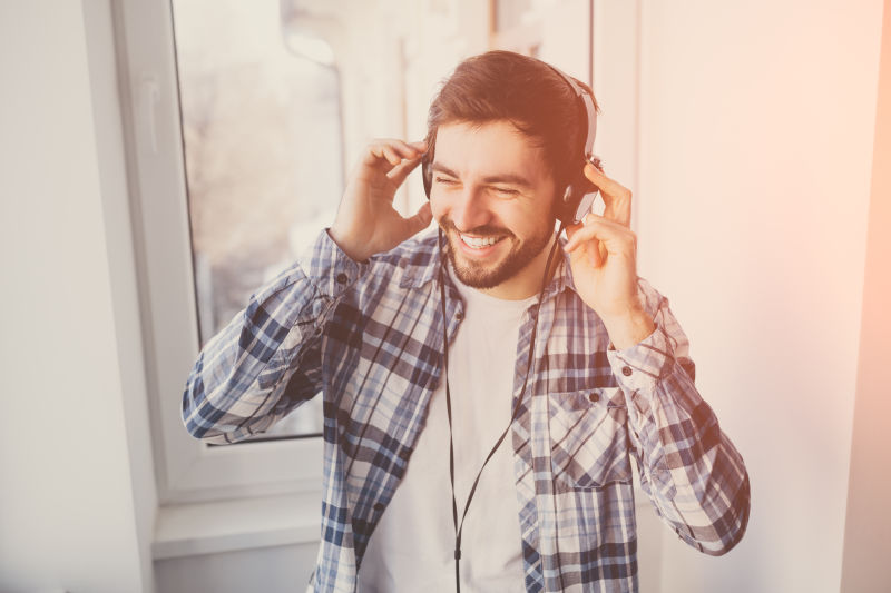戴耳机的男人微笑着听音乐