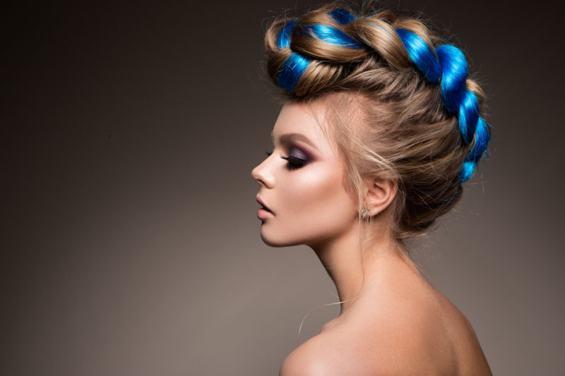 一个美丽女孩的时尚美丽肖像有着明亮的创意化妆和蓝色的头发