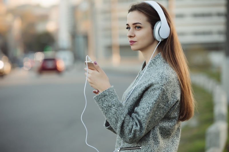 城市里用耳机听音乐的女人