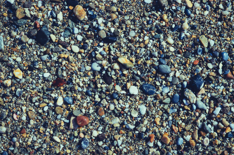 海滩上有很多潮湿的小石子小石子的纹理