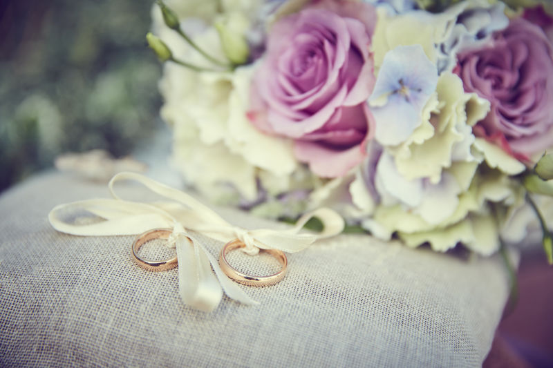 一张彩色的宏观照片-上面有一束粉红玫瑰白色小花和一个假钻石放在玫瑰和结婚鞋的中间