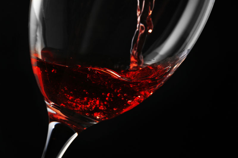 细水晶玻璃边缘有美丽卷曲的葡萄酒波
