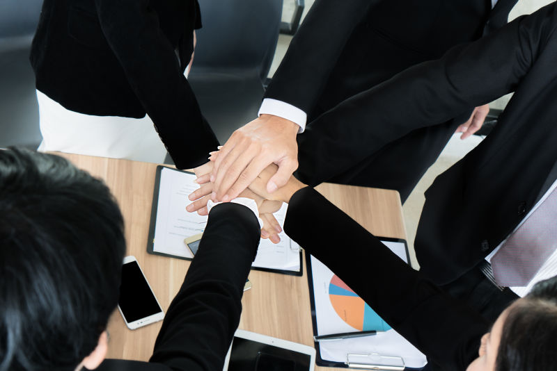 特写的商业伙伴在会议上堆手-业务人员协作团队合作联盟概念