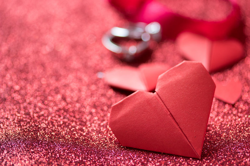 钻石戒指上的红色闪光纹理情人节和浪漫的概念结婚周年礼物
