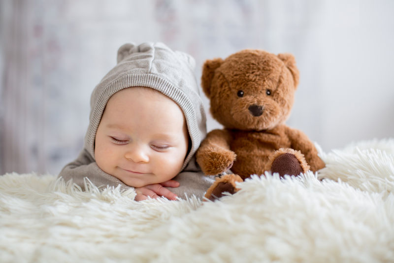 熊宝宝的甜蜜男孩睡在泰迪熊床上
