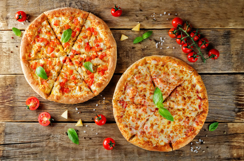比萨配奶酪鸡肉和新鲜的番茄片-以木材为背景-调色-选择性聚焦