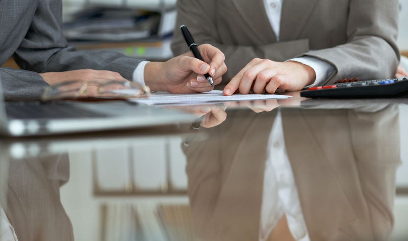 商务人士或律师在会议上签署合同-工作时人手的特写镜头
