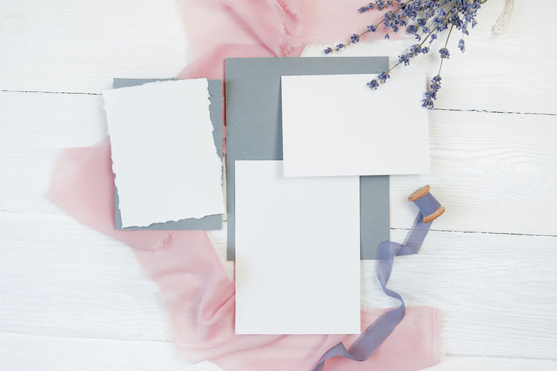 白色空白卡片色带背景为粉色和蓝色白色背景为薰衣草花用信封和空白卡片模拟平铺俯视图