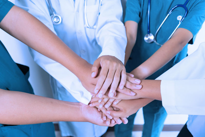 医生和护士协调医院的双手叠放概念团队合作快乐的医生作为团队协作-以获得激励成功的医疗保健蓝色调