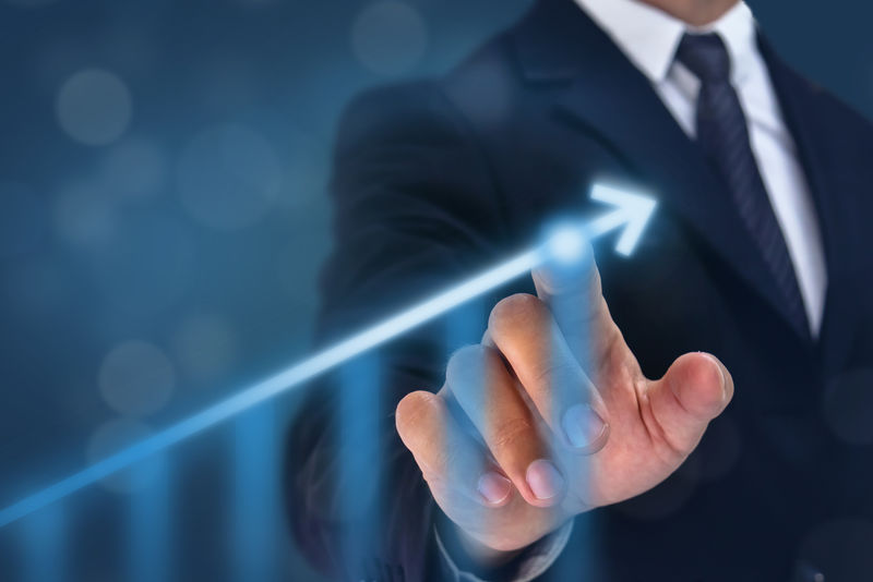 业务人员将手指向箭头图的顶部-增长率很高-公司或行业投资后的成功率和增长图