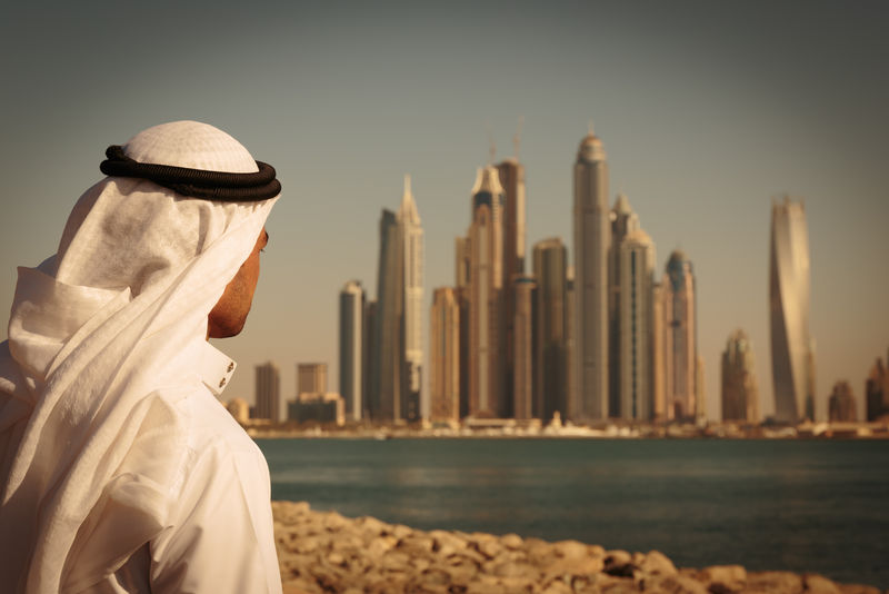 阿联酋迪拜码头的现代建筑穿着阿拉伯长裙的男人
