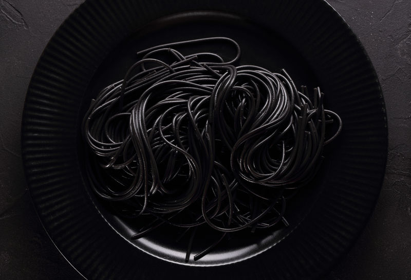 黑色意大利面-黑色背景的黑色餐具