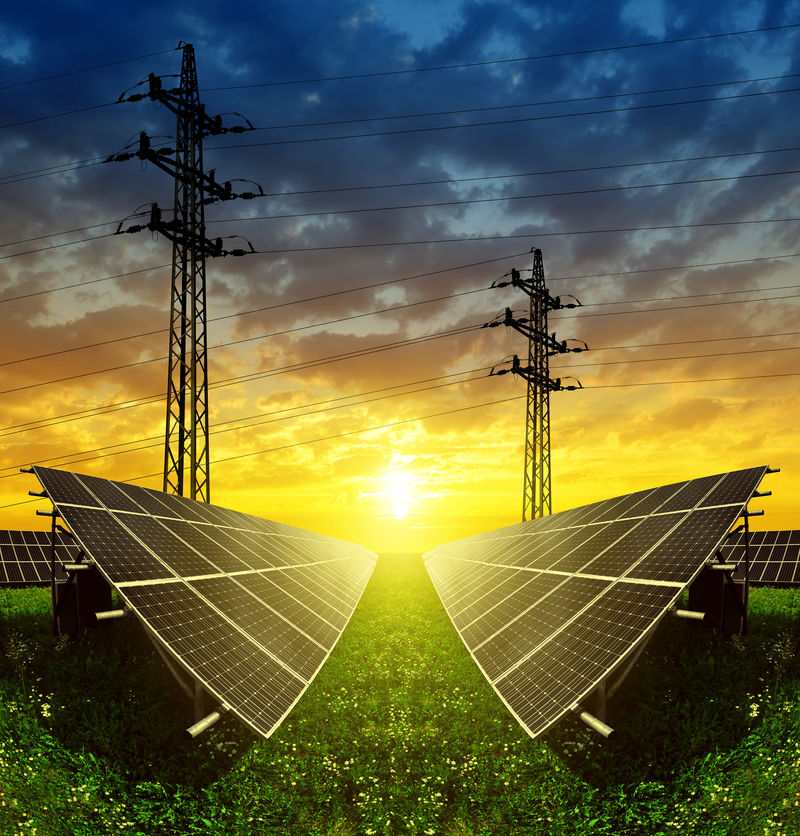 日落时带有电塔的太阳能电池板可持续资源的概念