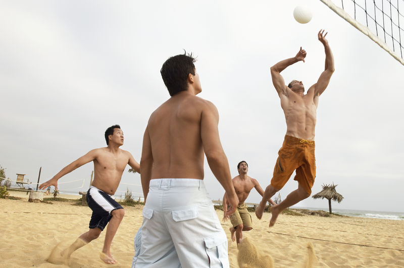 四个多男子在沙滩上打排球