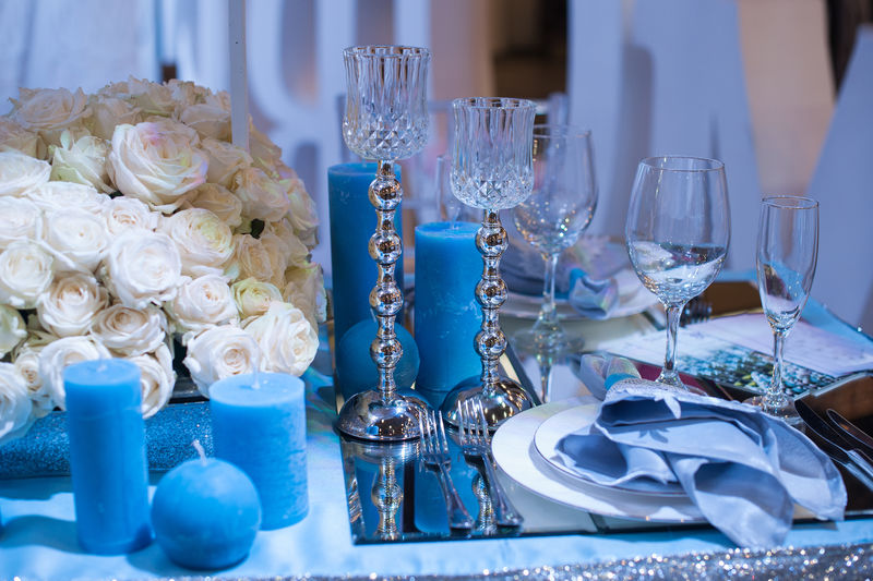 蓝色的婚礼装饰桌上的蜡烛和鲜花