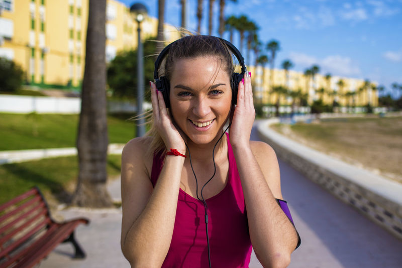 穿运动服的女人微笑着听音乐的肖像