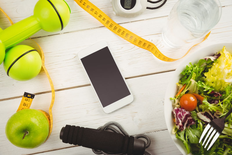 智能手机在木制桌子上显示健康的生活方式