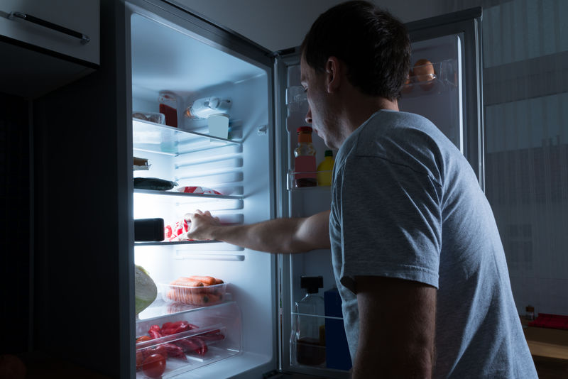 一个从冰箱里拿食物的人的肖像