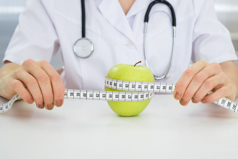 营养学家用卷尺测量青苹果的特写