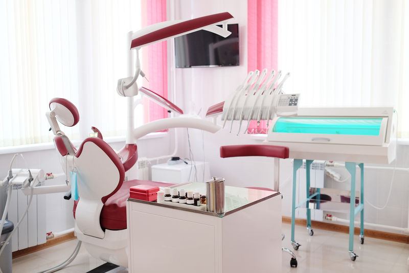 带红色椅子和工具的牙科诊所内部设计