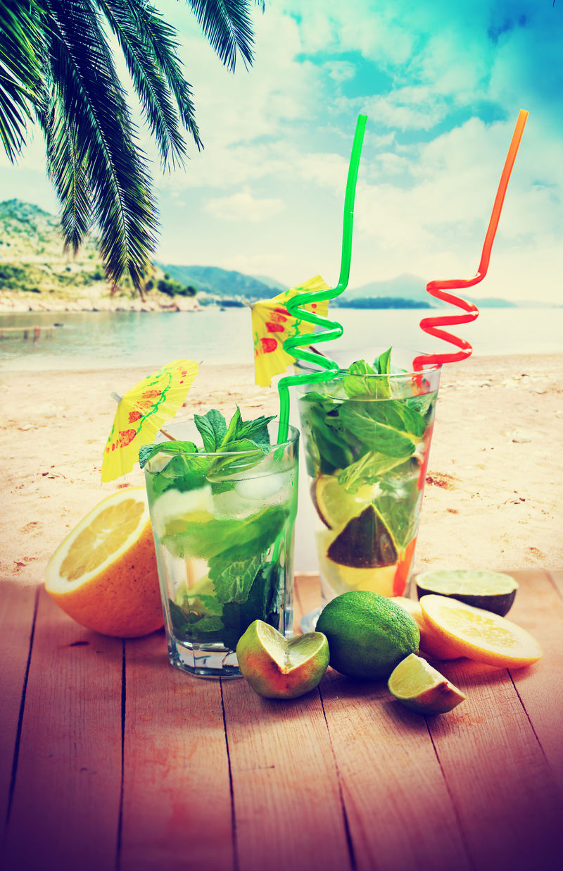 背景为莫吉托鸡尾酒和海滩/暑假背景为两杯莫吉托鸡尾酒