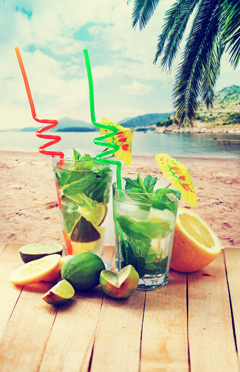 背景为莫吉托鸡尾酒和海滩/暑假背景为两杯莫吉托鸡尾酒