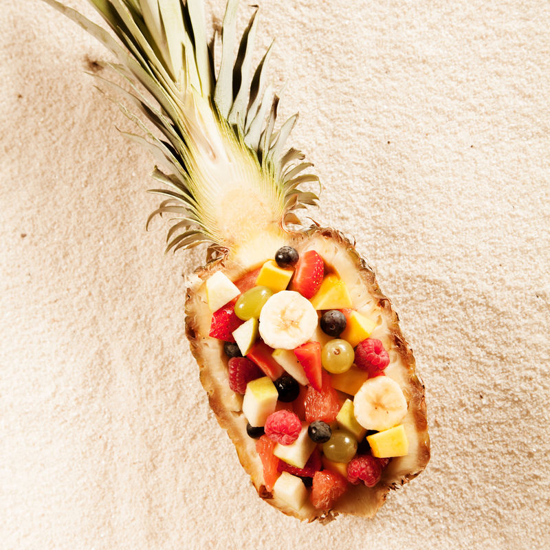 新鲜异国情调热带水果沙拉配半个菠萝在夏季阳光下呈白色纹理从头顶观看